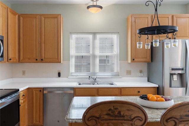 kitchen featuring light countertops, appliances with stainless steel finishes, backsplash, and a sink