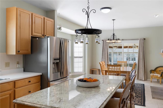 kitchen with stainless steel fridge, light brown cabinets, tasteful backsplash, and a wealth of natural light