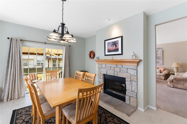 dining room with light tile patterned floors, visible vents, light colored carpet, and a stone fireplace