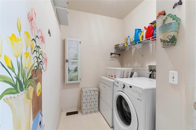 washroom with laundry area, baseboards, washing machine and clothes dryer, and light tile patterned floors