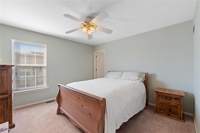 bedroom featuring baseboards, a ceiling fan, visible vents, and light colored carpet