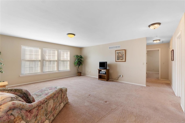 living area with light colored carpet, visible vents, and baseboards