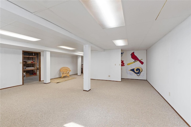 finished below grade area featuring a drop ceiling and carpet flooring