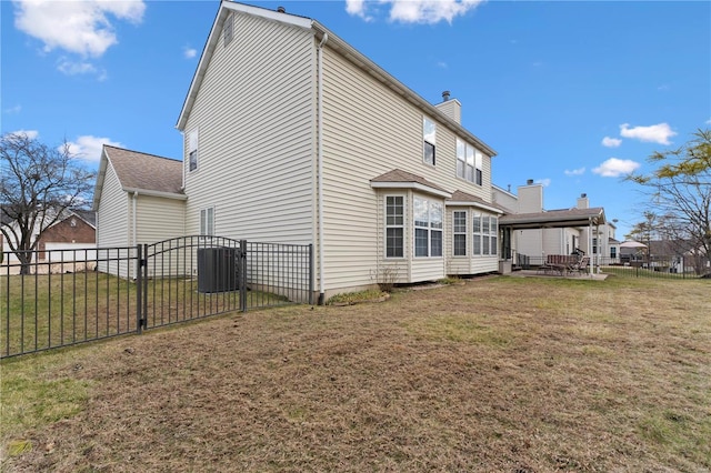 rear view of house with a patio area, a gate, fence, and a yard