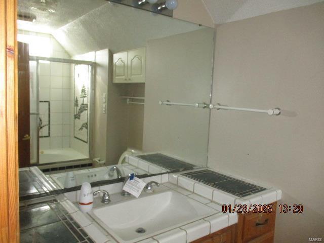 bathroom featuring lofted ceiling and sink