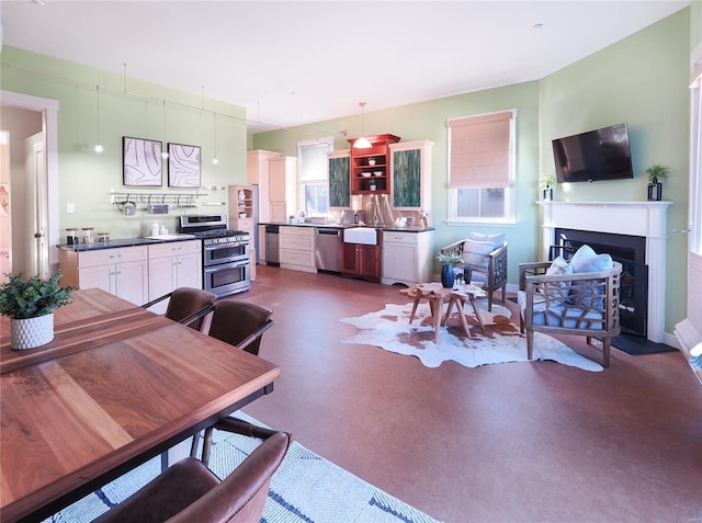 kitchen featuring hanging light fixtures, white cabinetry, and stainless steel appliances