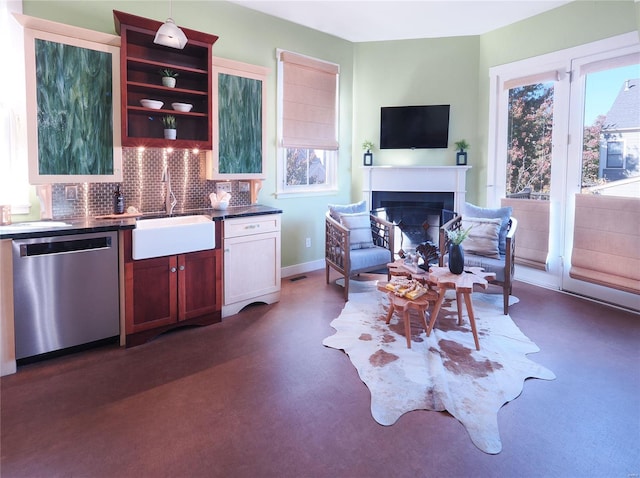 kitchen featuring tasteful backsplash, dishwasher, sink, and pendant lighting