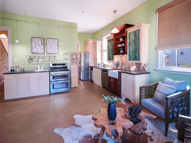 kitchen featuring sink, white cabinetry, decorative light fixtures, stainless steel appliances, and decorative backsplash