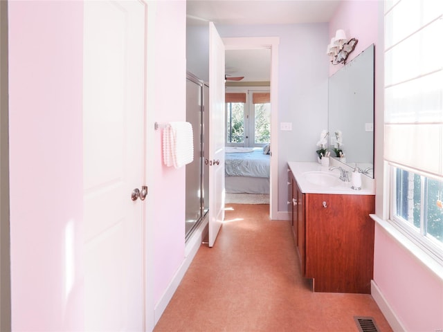 bathroom featuring vanity and a shower with door