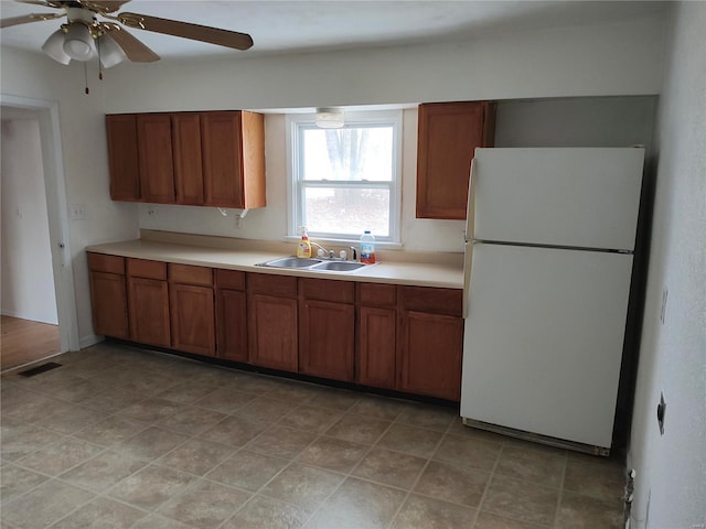 kitchen with sink, white refrigerator, and ceiling fan