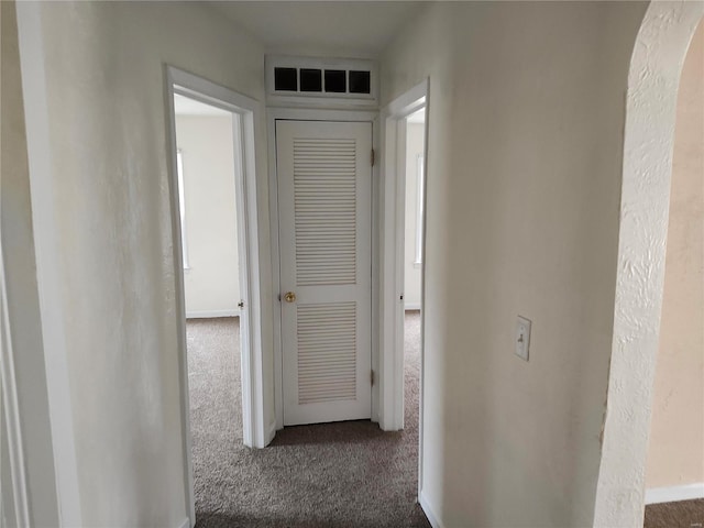 hallway featuring dark carpet