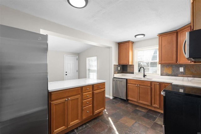 kitchen with appliances with stainless steel finishes, sink, and decorative backsplash