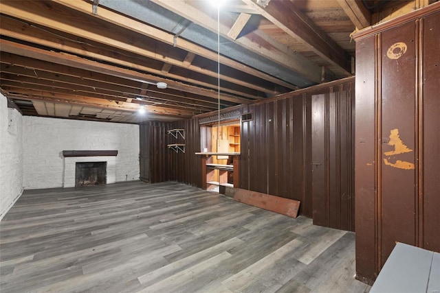 basement with hardwood / wood-style flooring and a stone fireplace