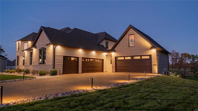 view of front of house featuring a garage, a front yard, driveway, and brick siding