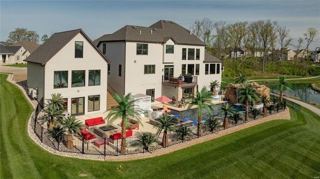 back of house with a fenced in pool, an outdoor living space, a balcony, a lawn, and a patio