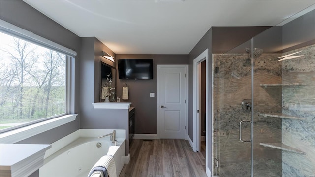 full bathroom featuring a shower stall, a healthy amount of sunlight, and a bath