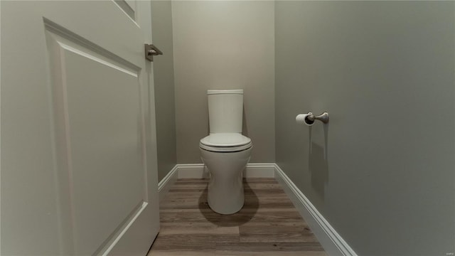 bathroom featuring baseboards, toilet, and wood finished floors