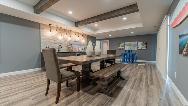 dining space with wet bar, baseboards, beamed ceiling, light wood finished floors, and recessed lighting