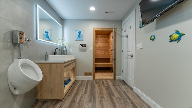 bathroom with baseboards, vanity, wood finished floors, and visible vents