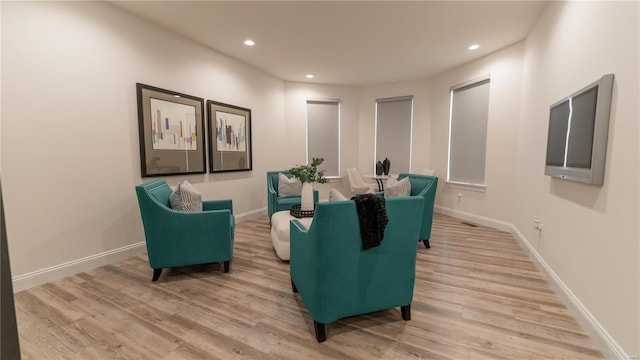 living area with recessed lighting, baseboards, and light wood-type flooring
