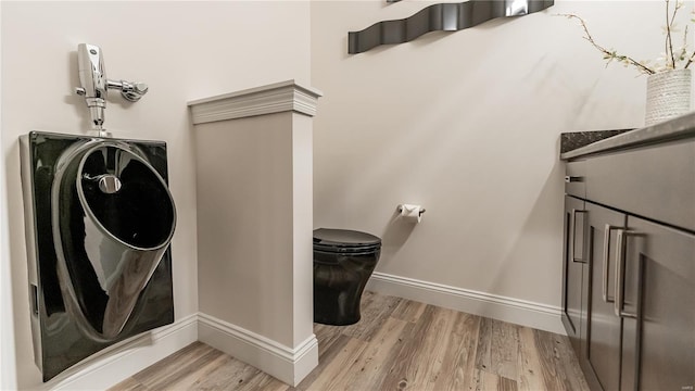 laundry room featuring baseboards, laundry area, and wood finished floors