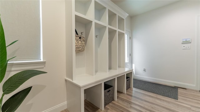 mudroom with baseboards, light wood finished floors, and visible vents