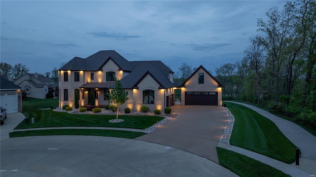 view of front of house featuring an attached garage, driveway, and a front yard
