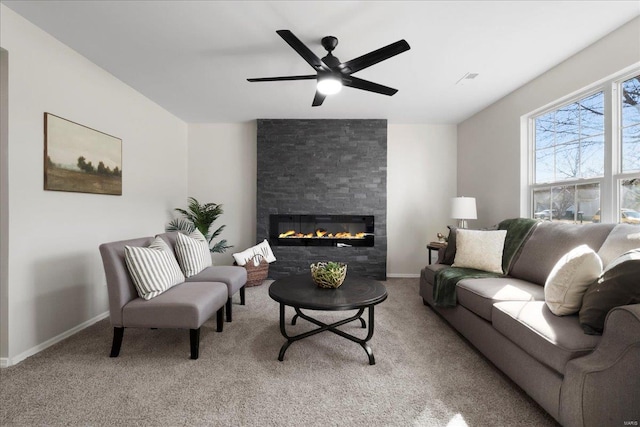 living room featuring carpet, a fireplace, baseboards, and ceiling fan