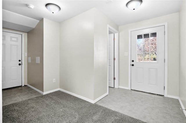 entrance foyer with baseboards and carpet flooring