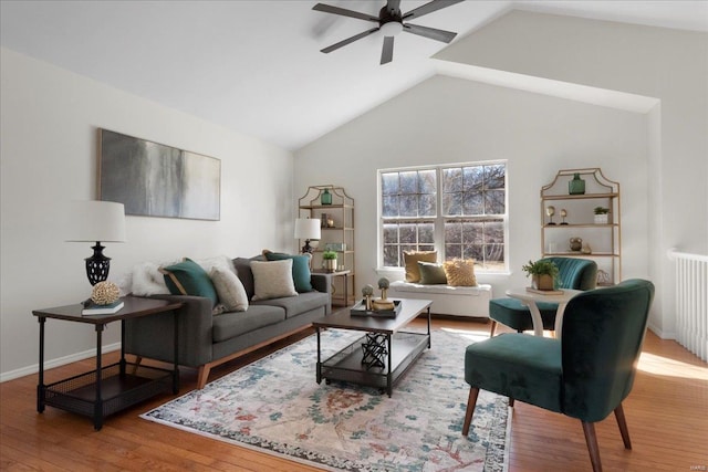 living area featuring lofted ceiling, hardwood / wood-style flooring, ceiling fan, and baseboards