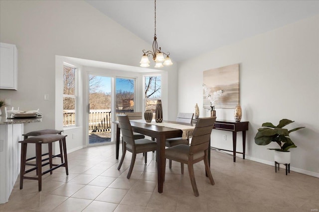 dining space with light tile patterned floors, vaulted ceiling, baseboards, and an inviting chandelier