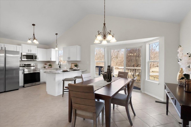 dining space featuring high vaulted ceiling, visible vents, baseboards, and an inviting chandelier