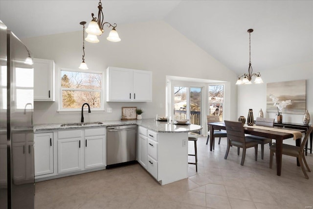 kitchen featuring a peninsula, an inviting chandelier, appliances with stainless steel finishes, and a sink