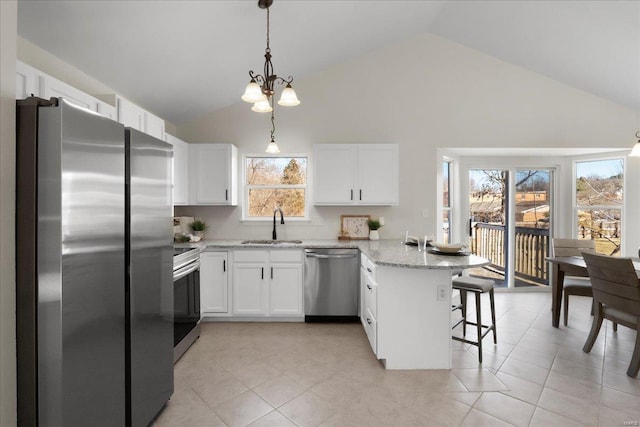 kitchen featuring a peninsula, white cabinetry, stainless steel appliances, and a sink