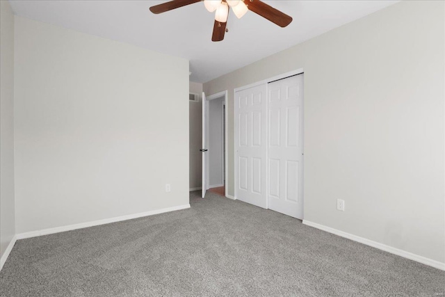 unfurnished bedroom featuring carpet floors, ceiling fan, baseboards, and a closet