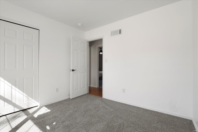 unfurnished bedroom featuring baseboards, visible vents, and carpet flooring