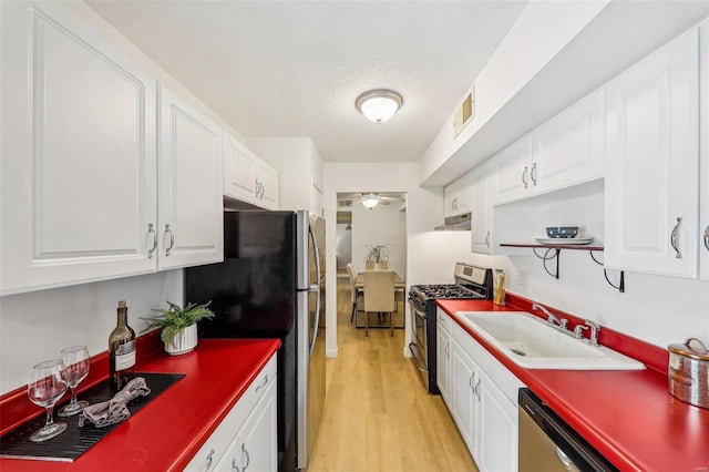 kitchen with stainless steel appliances, sink, white cabinets, and ceiling fan