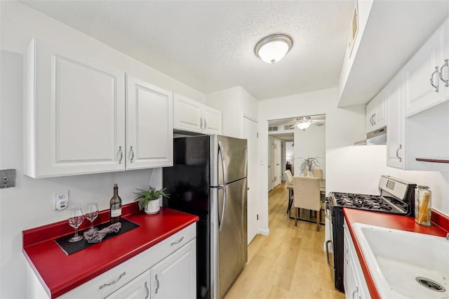 kitchen featuring sink, light wood-type flooring, ceiling fan, stainless steel appliances, and white cabinets