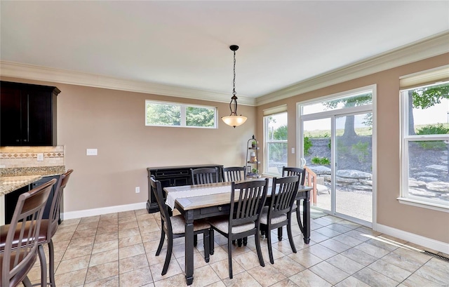 dining space featuring light tile patterned floors, crown molding, and plenty of natural light