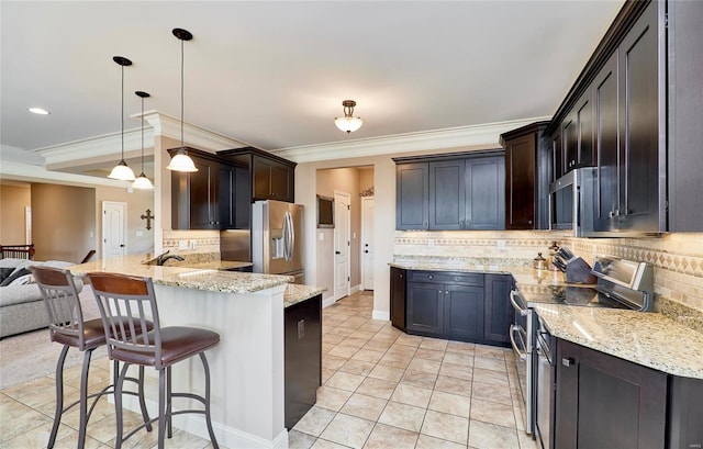 kitchen featuring appliances with stainless steel finishes, pendant lighting, tasteful backsplash, kitchen peninsula, and light stone countertops