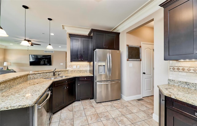 kitchen with sink, hanging light fixtures, stainless steel appliances, crown molding, and light stone countertops