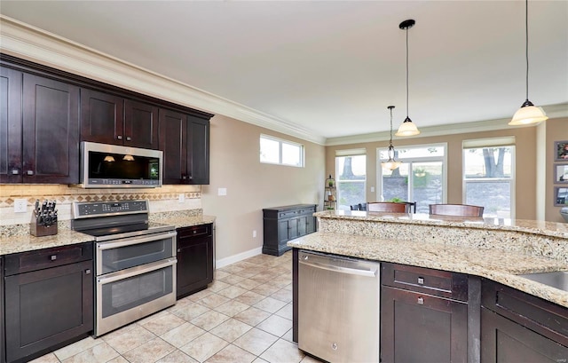 kitchen with stainless steel appliances, decorative light fixtures, dark brown cabinets, and backsplash