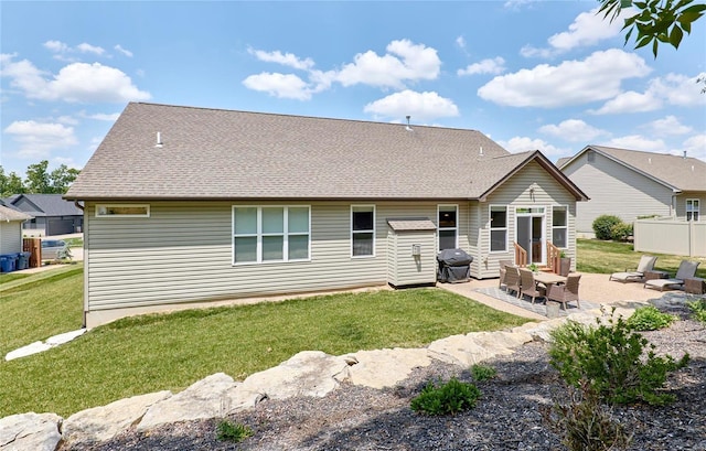 rear view of house with a yard and a patio