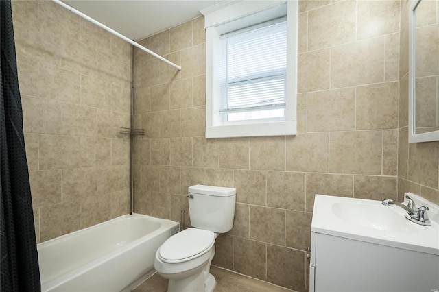 full bathroom with vanity, tile walls, toilet, and shower / tub combo with curtain