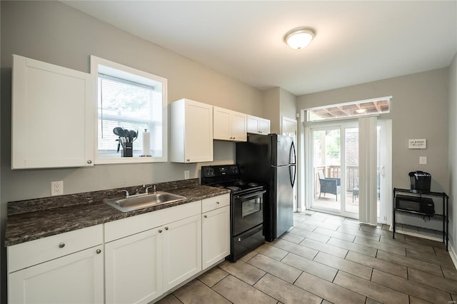 kitchen featuring sink, black appliances, dark stone counters, and white cabinets