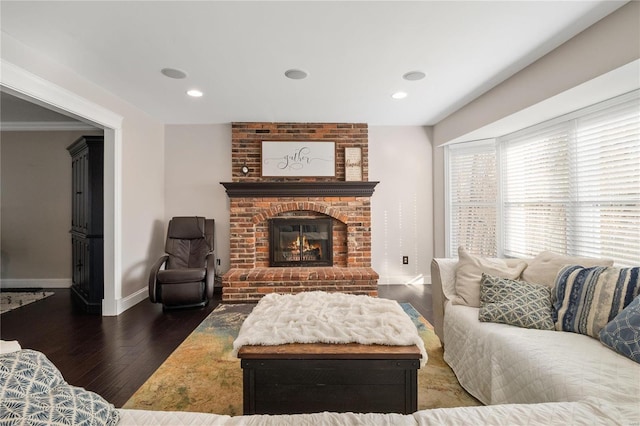 living room with dark wood-type flooring and a brick fireplace