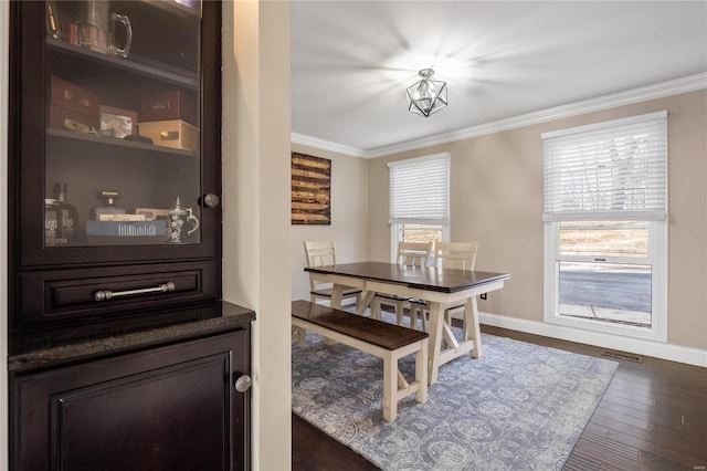 dining room featuring dark hardwood / wood-style flooring and ornamental molding