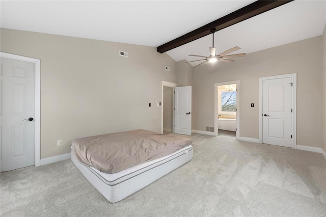 bedroom with lofted ceiling with beams, light carpet, and ensuite bath