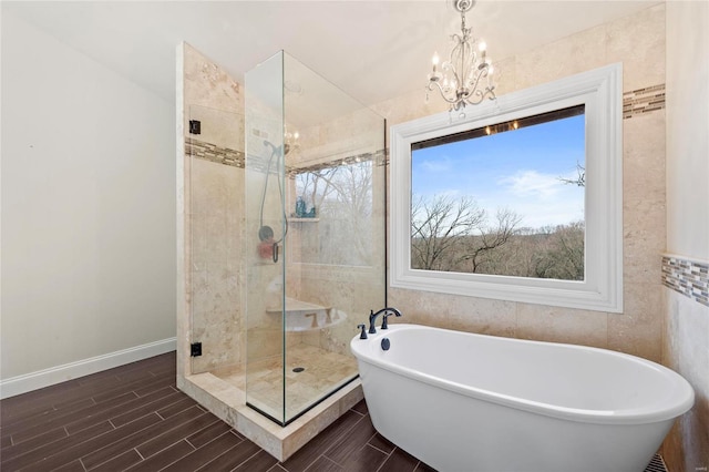 bathroom featuring shower with separate bathtub, tile walls, and an inviting chandelier