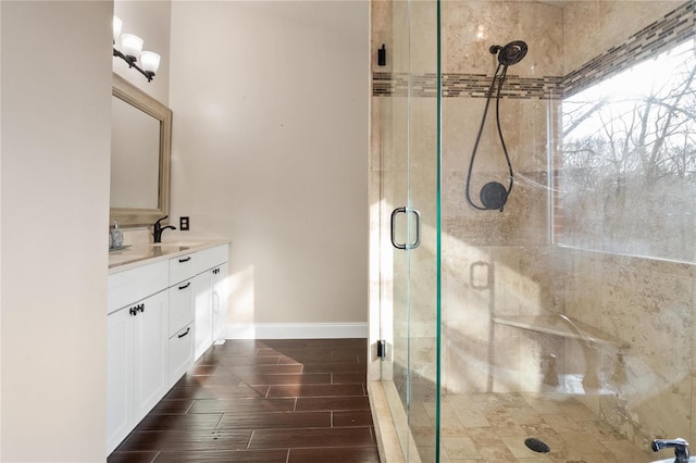 bathroom featuring wood-type flooring, a shower with door, and vanity